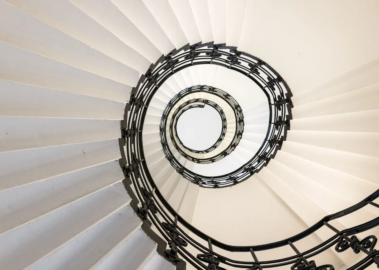 Escalier intérieur en colimaçon avec rambarde en fer forgé