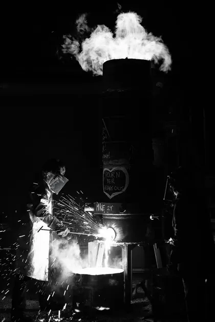 Forgeron façonnant le fer au marteau, de nuit