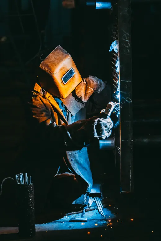 Artisan soudant une pièce métallique